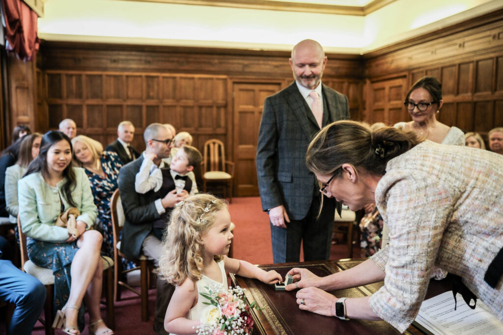 Young ring-bearer prepares to present wedding rings to bride and groom