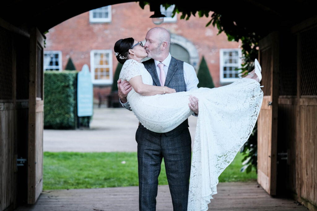 Groom carrying bride and kissing