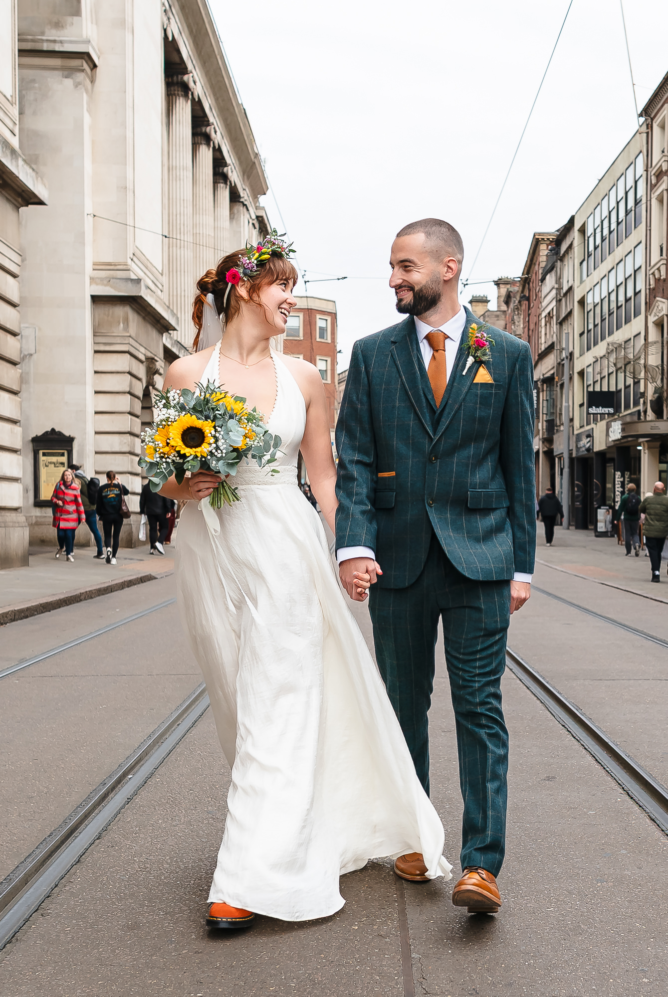 bride and groom in front of colourful blue background smile and kiss on their fun wedding day taken by alternative wedding photographer Glasgow