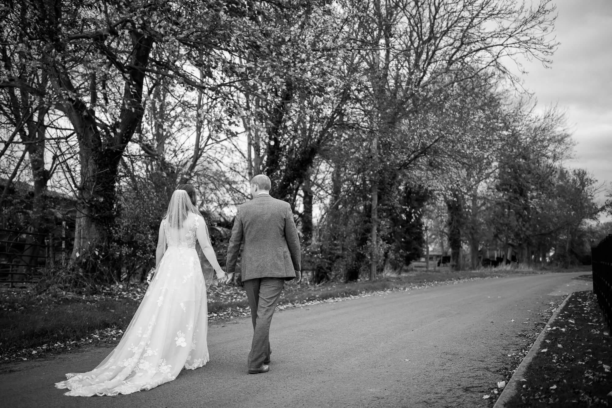 Couple walking outside Manor Barn Harlton wedding, Cambridge 